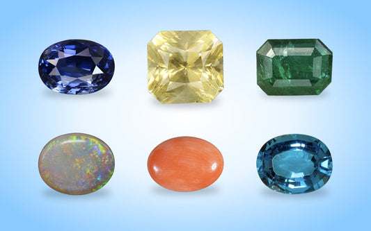 Blue sapphire, yellow sapphire, emerald, opal, red coral and blue topaz gemstones on a blue aura background